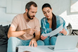 couple looking over paperwork and laptop
